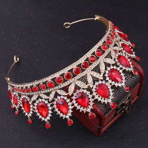 Detailed close-up of Baroque crown with red crystals and gold alloy base on a vintage box