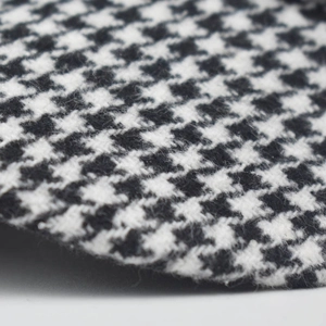 Macro shot of black and white houndstooth wool blend fabric on a stylish winter beret hat