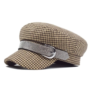 Detail of houndstooth newsboy cap with rhinestone band and silver horseshoe buckle