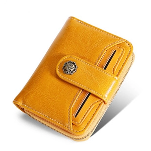 Detail of yellow leather wallet with metallic rose snap button and stitched texture
