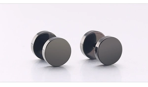 Close-up of matte black barbell stud earrings with circular disk design in titanium steel