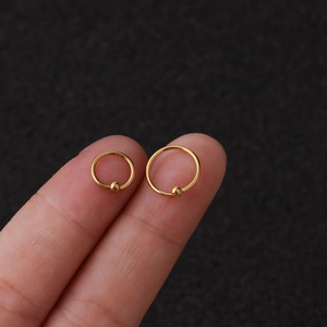 Boucles d'oreilles créoles dorées en acier inoxydable en deux tailles sur doigts