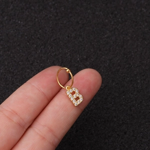 Vue rapprochée d'une boucle d'oreille créole en acier doré avec un pendentif lettre B brillant