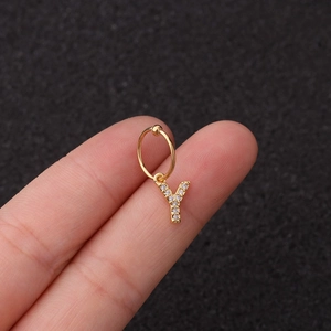 Détail d'une boucle d'oreille en or avec pendentif lettre Y et pierres en zircone