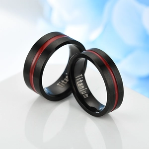 Macro shot of black matte titanium couple rings with sleek red line inlay detail