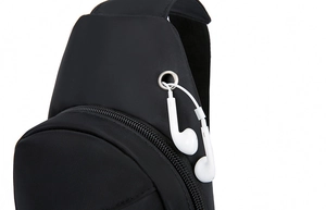 Detail of the earphone port on a black crossbody bag with white cable demonstration