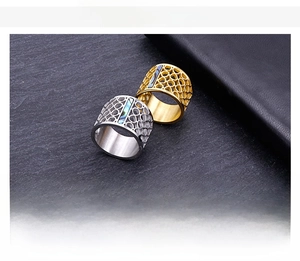 Detail of hollow mesh stainless steel rings with abalone shell inlay in steel and gold