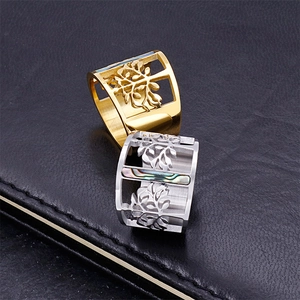 Modern gold and silver stainless steel rings with hollow tree design on leather surface