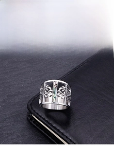 Macro detail of silver tree of life ring with colorful abalone shell inlay on black leather
