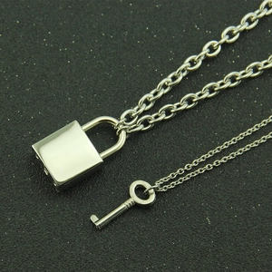 Set of polished silver lock and key necklaces on a black textured background