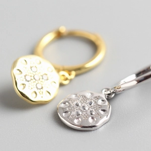 Macro detail of S925 sterling silver starburst earrings in gold and silver finish
