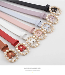 Close-up of thin faux leather belts with pearl buckles in seven assorted vibrant colors