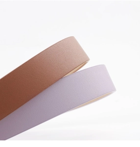 Detailed view of the leather texture on brown and lavender fashion belts with rhinestones