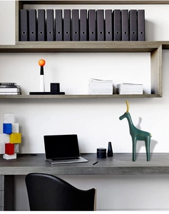 Detail einer modernen grünen Keramikgiraffe mit Goldhörnern im Heimbüro-Ambiente