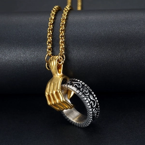 Detailed view of bicolor skull hand pendant with silver ring on golden chain