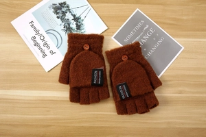 Detail view of brown knitted flip-top gloves with buttons and fashion brand label