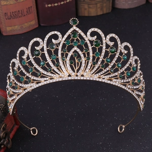 Macro detail of luxury baroque crown featuring emerald green crystals and gold metal work