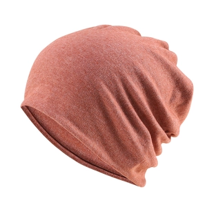 Detail of red-brown slouchy beanie with soft knit texture and natural folds for winter