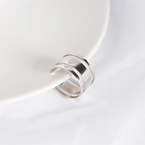 Close-up of a silver S925 sterling silver triple-layered hollow ring on a ceramic plate