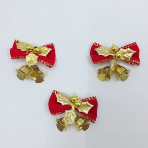 Détail de nœuds de Noël en velours rouge avec clochettes dorées et feuilles de houx