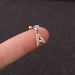 Macro shot of gold stainless steel cartilage stud with letter A pendant and zircon stones