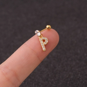Detailed close-up of a golden crystal-paved letter P earring charm held on a fingertip