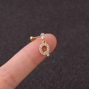 Macro shot of gold stainless steel letter Q stud earring with sparkling zircon stones