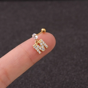 Close-up of gold-plated letter M piercing earring with sparkling cubic zirconia stones