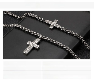 Detail of burnished black stainless steel cross necklace and bracelet set on leather