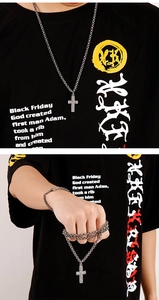 Detail view of silver cross pendant necklace and heavy chain bracelet for men