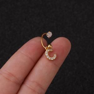 Gros plan détaillé d'une boucle d'oreille dorée lettre C avec zircons brillants