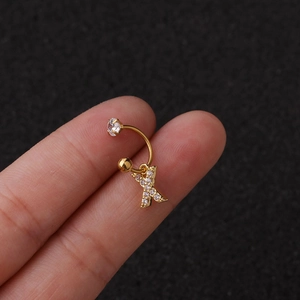 Gros plan sur un anneau d'oreille doré en forme de C avec pendentif lettre X en zircon
