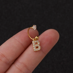 Gros plan de la boucle d'oreille dorée lettre B avec oxydes de zirconium scintillants