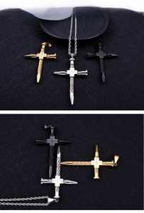 Close-up of twisted cross pendant necklaces in gold, silver, and matte black steel