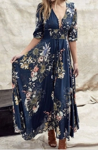 Gros plan détaillé du col en V et du motif floral sur la robe longue bohème bleu marine
