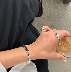 Minimalist silver smile chain ring and layered band styled with a matching open cuff