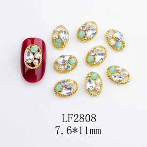 Detailed view of 7.6*11mm gold alloy nail jewels with mint green gems and rhinestones