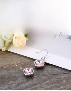 Detail shot of square-cut pink zircon drop earrings with elegant silver hooks