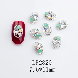 Macro shot of oval nail art alloy charms with mint green rhinestones and pearls