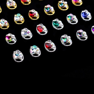 Macro detail of oval twist frame alloy nail charms with colorful crystals and pearls
