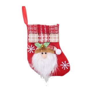 Detail of red Christmas stocking with a 3D Santa Claus figure and a small golden bell