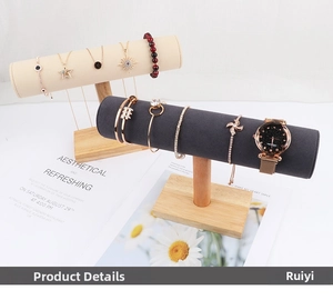 Detailed view of wood jewelry stands with beige and dark gray velvet cylinder displays