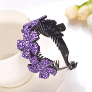 Detailed close-up of purple rhinestone flower hair clip on a white ceramic cup edge