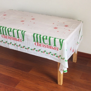 Détail de la nappe de Noël en plastique blanc avec étoiles rouges et motifs de houx