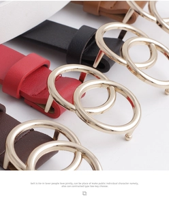 Close-up of four colored leather belts featuring golden interlocking double ring buckles