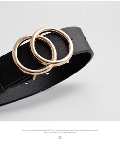 Close-up of black leather belt featuring elegant gold double ring buckle detail