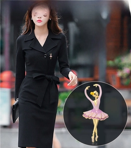 Dettaglio di elegante spilla ballerina con tutu rosa indossata su abito nero
