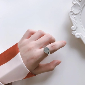 Macro shot of 925 silver signet ring with vintage engraved figure on model's hand
