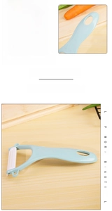 Macro detail of Y-shaped ceramic peeler with mint green handle and sharp blade on wood