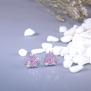 Detailed macro view of pink floral stud earrings with marquise-cut stones and tiny zircon accents